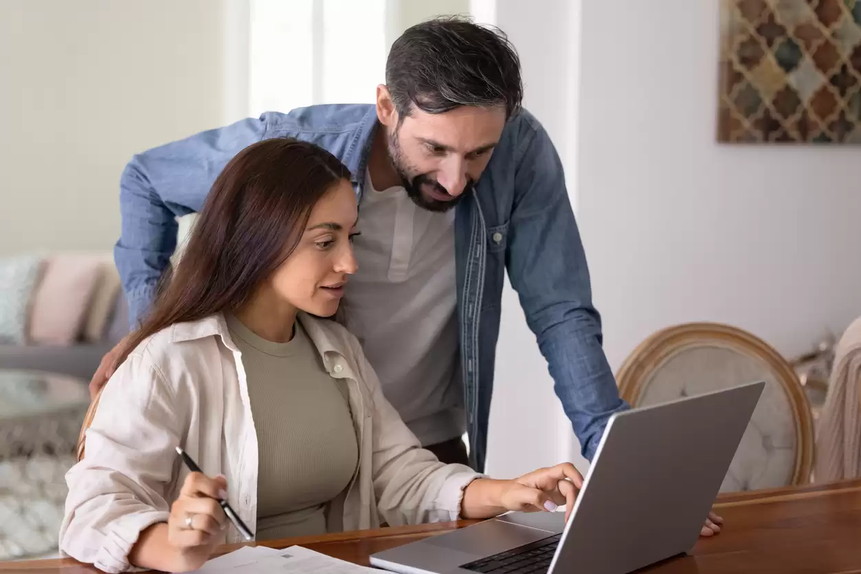 Young couple, looking at home computer, talking.