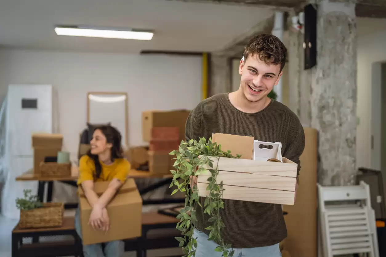 Young couple moving house carrying boxes